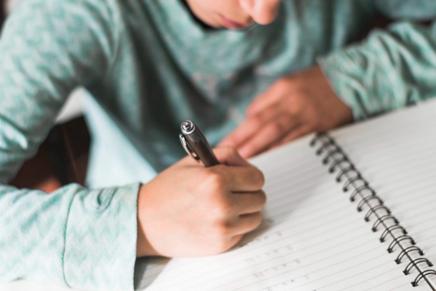 crop kid writing notebook